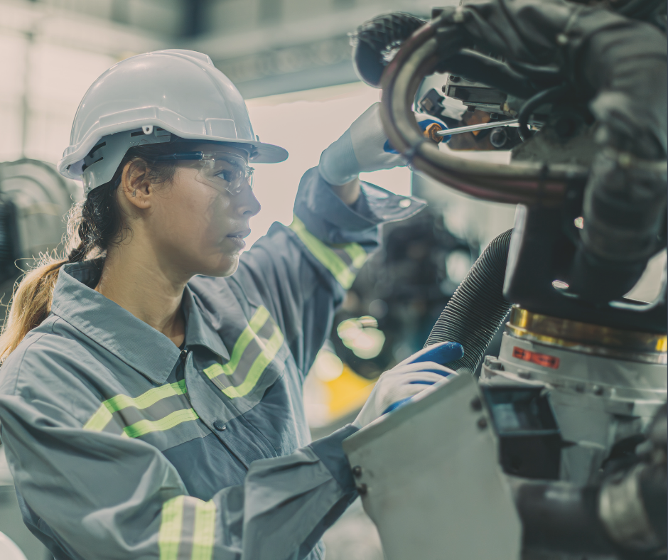 Woman in a hard hat tinkering with advanced technology manufacturing