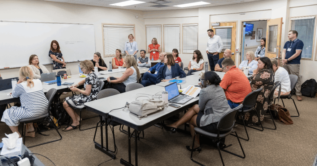 A wider view of a group of diverse professionals participating in an informal strategy session in a well-lit office space